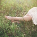 Barefoot woman legs sit in grass summer day sunlight Royalty Free Stock Photo