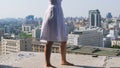 Barefoot woman walks on edge of abandoned building rooftop, reckless daredevil