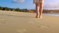 Barefoot woman walks on ocean beach wet sand leaving footprints Royalty Free Stock Photo