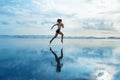 Sporty girl running by beach along sea surf Royalty Free Stock Photo