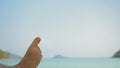 Barefoot young man removes sand from foot lying on beach Royalty Free Stock Photo