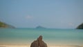 Barefoot young man removes sand from foot lying on beach Royalty Free Stock Photo