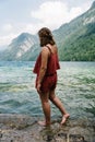 Barefoot young woman standing on rock looking at beautiful lake Royalty Free Stock Photo