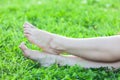 Barefooted attractive female feet on green grass