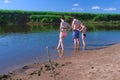 Barefooted family in swimsuits in river walking in water at Summer warm day. Royalty Free Stock Photo