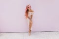 Barefooted laughing girl in elegant dress dancing in studio. Indoor shot of amazing young female mo