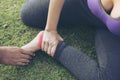 Barefooted Runner woman sit on grass in the park  touching painful twisted or broken ankle. Athlete runner training accident Royalty Free Stock Photo