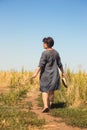 Barefooted woman on path through field