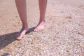 Barefooted woman walks on sea shells on sand beach makes nature feet massage. Royalty Free Stock Photo