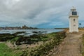 The Barfleur harbor lighthouse and port at low tide in the evening Royalty Free Stock Photo