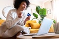 Bargain. Excited, happy African American woman shop online during sale season using laptop and credit card. Copy space. Royalty Free Stock Photo