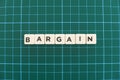 Bargain word made of square letter word on green square mat background