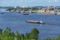 A barge carries cargo on the river. Transportation of wood by river transport.