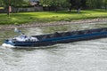 A barge carrying fine coal on the Rhine in western Germany with a lawn in the background.