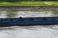 A barge carrying fine coal on the Rhine in western Germany with a lawn in the background.