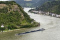 A barge with coal sailing on the river Rhine in western Germany, visible buildings on the river bank, aerial view.