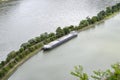 Barge with a covered deck attached to the river bank, aerial view.