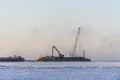 Barge with crane. Dredger working at sea. Sunset in Arctic sea. Construction Marine offshore works. Dam building, crane, barge,