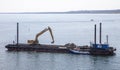 Barge with excavator carrying out dredging work outside the harbor in Fredrikshamn Denmark Royalty Free Stock Photo