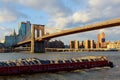 The barge floats along the Hudson River in the background of the Brooklyn Bridge