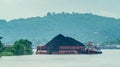 Barge full of black coal cruising on Mahakam River, Borneo, Indonesia. Royalty Free Stock Photo