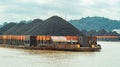 Barge full of black coal cruising on Mahakam River, Borneo, Indonesia. Royalty Free Stock Photo