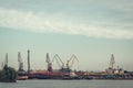 A barge in the river port and working cranes