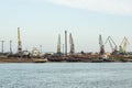 A barge in the river port and working cranes