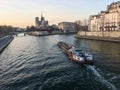 Barge on the Seine in front of Notre Dame cathedral, late afternoon, in Paris, France