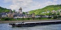 Barge traveling past medieval village on the Rhine River