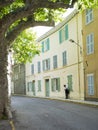 Man wears hat and leans against yellow wall in the old medieval french provence town of bargemon