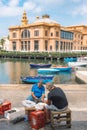 Local fishermen washing, cleaning and selling fresh raw sea fruits Royalty Free Stock Photo