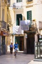 BARI, ITALY - JULY 11, 2018, Scenes from the life of center of Bari: laundry is drying on the streets, a man riding a bicycle Royalty Free Stock Photo