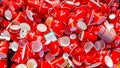 Bari, Italy - March 10, 2019: Many red empty paper cups, thrown in a container, by runners with isotonic drink provided by Enervit