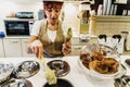 Bari, Italy - March 10, 2019: Waitress in a gelateria ice cream shop preparing an ice cream in waffle