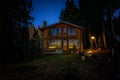 BARILOCHE, ARGENTINA, JUNE 19, 2019: Exterior of a wooden cozy and relaxing cabin in the forest during the last moments of light Royalty Free Stock Photo