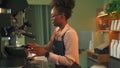 Barista Afro-American lady cleans coffeemachine with steam Spbas