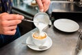 Barista in cafe or coffee bar preparing cappuccino