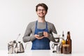 Barista, cafe worker and bartender concept. Portrait of cheerful pleasant young male employee in apron invite everyone Royalty Free Stock Photo