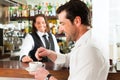 Barista with client in his cafe or coffeeshop Royalty Free Stock Photo