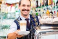 Barista in coffee bar offers latte macchiato in glass Royalty Free Stock Photo
