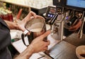 Barista in coffee bar preparing proper cappuccino pouring frothed milk into cup of coffee, making latte art, pattern