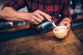 Barista creating latte art with cappuccino at local bistro, pub and cafe shop