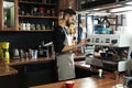 Barista frothing milk in metal pitcher with coffee machine steam wand Royalty Free Stock Photo