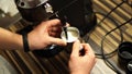 Barista frothing milk in a milk jug with a cappuccinatore of a coffee machine