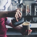 Barista girl pouring milk into coffee. Process of making cappuccino or latte Royalty Free Stock Photo