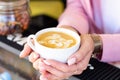 Barista girl serves ready-made latte coffee