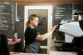 The barista girl turns on the coffee machine in the cafe in the morning to make coffee. A woman stands near a coffee Royalty Free Stock Photo