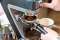 Barista grinding coffee beans using coffee machine