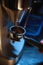 Barista grinding coffee beans using coffee machine